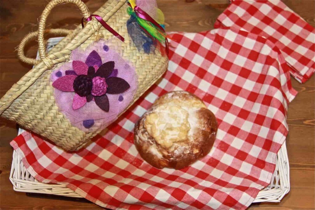 Mona de pascua encima de mantel junto a bolso