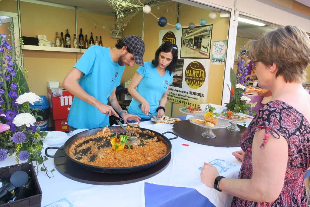 Pareja vestida de hazul haciendo paella para feria de Calpe